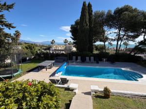 a swimming pool in a yard with chairs at 5 Bedroom Villa with HEATED Pool with breath-taking Sea Views, Walking distances to Shops Restaurants Beach in Manilva