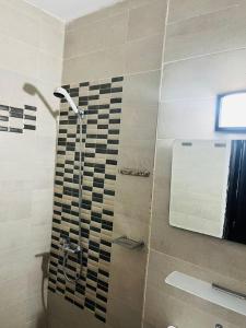 a bathroom with a shower with a glass door at Résidence Ephrata in Cocody +10 photos