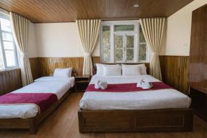 a bedroom with two beds with towels on them at Hotel Tashiling Stay in Pelling