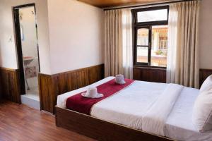 a bedroom with a bed and a window and a shower at Hotel Tashiling Stay in Pelling