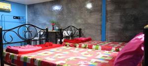a bedroom with two beds with red sheets at Krasom Homestay in Phang-nga +17 photos