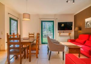 a living room with a table and a red couch at Cal Metge de Gualba in gualba de Dalt