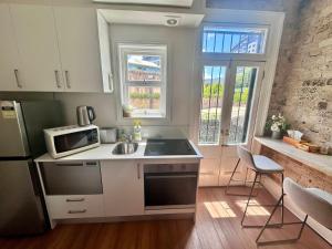 a kitchen with a sink and a microwave at 2 Bedroom Pyrmont Terrace House in Sydney
