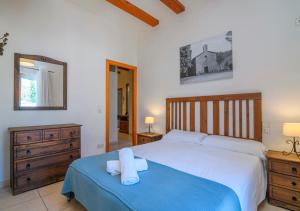 a bedroom with a large bed with a blue blanket at Cal Metge de Gualba in gualba de Dalt
