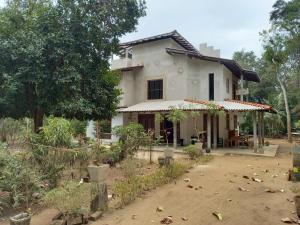 a house with a yard in front of it at Silent Peacock Villa And Restaurant in Tangalle