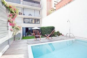 a balcony with a pool and chairs and a building at Apartment Barcelona Rentals - Private Pool and Garden Center in Barcelona