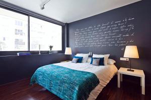 sypialnia z łóżkiem ze ścianą z napisem w obiekcie Apartment Barcelona Rentals - Private Pool and Garden Center w Barcelonie