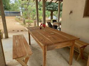 a wooden table with a bench and a wooden table and sidx sidx sidx at Silent Peacock Villa And Restaurant in Tangalle +75 photos