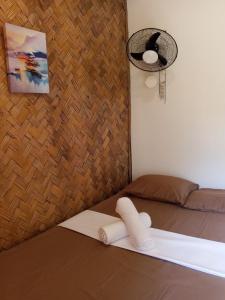 a room with a bed with a fan and a lamp at C and C Place in San Vicente