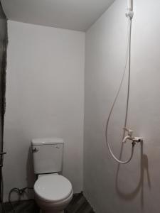 a bathroom with a toilet with a shower hose at C and C Place in San Vicente