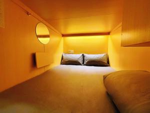 a small room with a bed and a light at Coller Chinatown in Singapore +34 photos