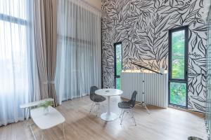 a room with a table and two chairs and a wall with aanova at Heaven Sukhumvit 62Villa in Bangkok