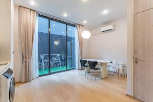 a dining room with a table and a large window at Heaven Sukhumvit 62Villa in Bangkok