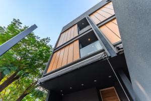 a house with wooden panels on the side of it at Heaven Sukhumvit 62Villa in Bangkok