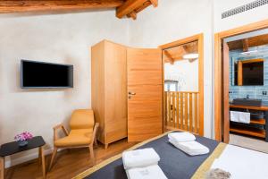 a room with a bed and a chair and a television at Luxury Jerini House with pool and wellness in Bajčići +75 photos