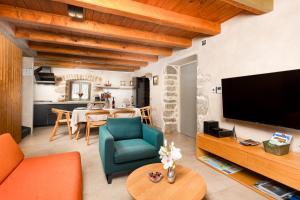 a living room with a large television and a dining room at Luxury Jerini House with pool and wellness in Bajčići
