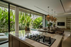 an open kitchen and dining room with a stove top oven at Kono Villas & Resort in Ungasan