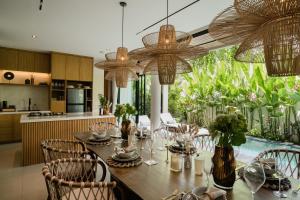 a kitchen and dining room with a table and chairs at Kono Villas & Resort in Ungasan