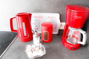 a kitchen counter with two red cups and a blender at Ferienwohnung Schwalbennest in Kronau