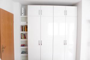 a white closet with white cabinets in a room at Ferienwohnung Schwalbennest in Kronau