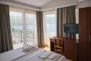 a hotel room with a bed and a desk and window at Villa Mesokastro in Ohrid