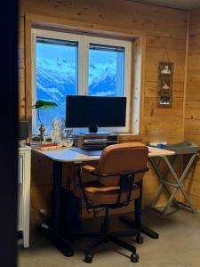 a desk with a computer monitor and a chair at Charming 6 bed chalet in 4 Valleés in Iserables