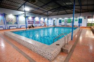 a large swimming pool with blue water in a building at Canalta Hotel Restaurant Bar in Jaipur
