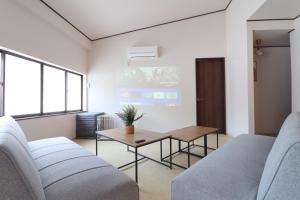 a living room with two couches and a table at TOHANA Style ペット宿泊可能 カラオケルーム有り in Hanamaki