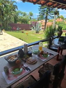 a table with food and drinks on a patio at Caminho das Pedras 206 in São Pedro da Aldeia