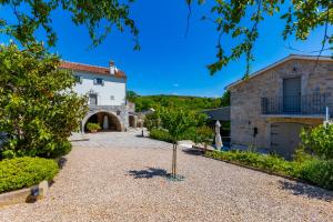 an external view of a house with a driveway at Luxury Jerini House with pool and wellness in Bajčići