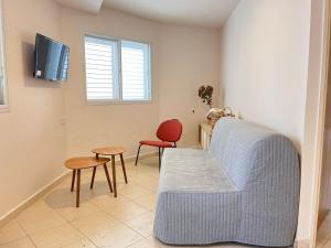 a living room with a blue couch and a red chair at Galilee Nook in Kefar Weradim