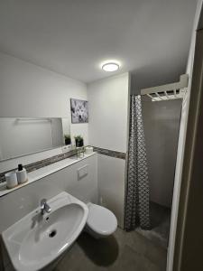a white bathroom with a sink and a toilet at Die kurPark Eule in Mölln