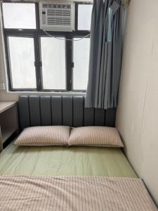 a small room with a bed and a window at 旅居2wubin in Hong Kong