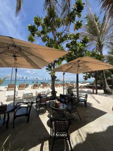 a table and chairs with umbrellas on a beach at Andaman Beach Resort by Zodiac in Ko Lipe