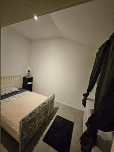 a bedroom with a bed and a white wall at Die kurPark Eule in Mölln