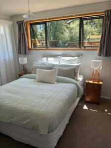 a bedroom with a large bed and a window at Flax Ridge in Hokitika Airport