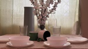 a table with plates and bowls and a vase with flowers at Aralu in Bangalore