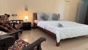 a bedroom with a bed and a couch and a chair at Aralu in Bangalore