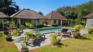 a villa with a swimming pool in a yard at CharPoot Cottage Khao Lak in Khao Lak