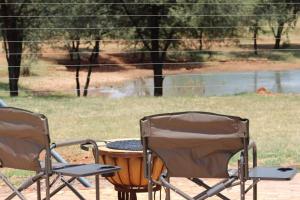 two lawn chairs and a table and a barrel at Little Amanzi in Pienaarsrivier