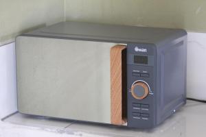 a toaster oven with its door open on a counter at Little Amanzi in Pienaarsrivier