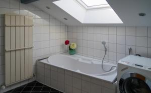a bathroom with a tub and a washing machine at Ferienwohnung Vögel in Langenegg +71 photos