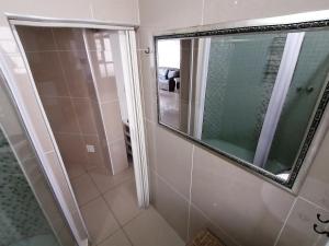 a bathroom with a shower and a mirror at Seaview Apartment Amanzimtoti in Amanzimtoti +20 photos