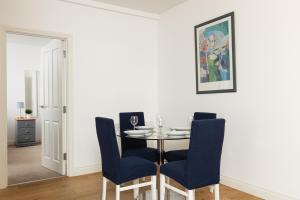 a dining room with a table and blue chairs at New! Bright 2BR Flat with Patio in Elmers End