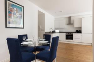 a dining room with a table and chairs and a kitchen at New! Bright 2BR Flat with Patio in Elmers End
