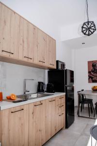 a kitchen with wooden cabinets and a black refrigerator at Casa De Lago in Agios Nikolaos