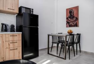 a black refrigerator in a kitchen with a table at Casa De Lago in Agios Nikolaos +28 photos