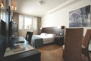 pokój hotelowy z łóżkiem i biurkiem w obiekcie Hotel Delfino Venezia Mestre w Mestre