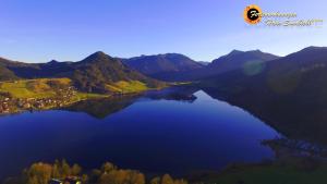 vistas a un lago en medio de las montañas en Haus Sonnbichl, en Schliersee