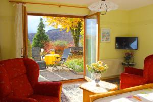 a living room with a door open to a patio at Pension Höchemer in Bad Bocklet